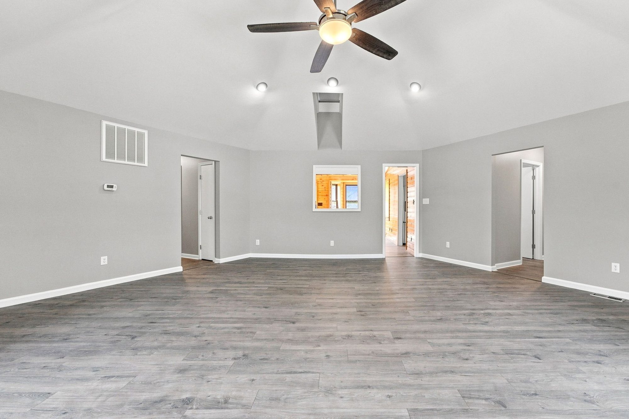Open great room with wood-paneled walls